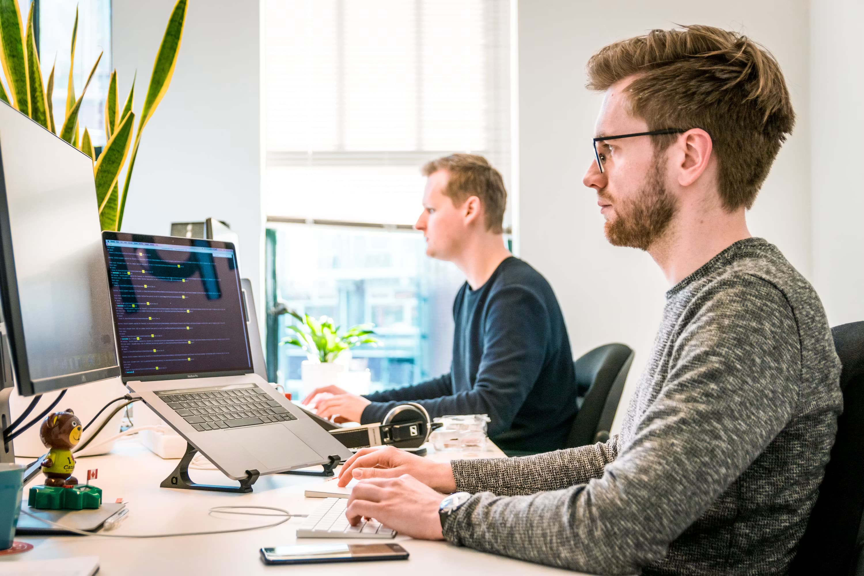 Deux spécialistes travaillant à des postes informatiques dans un bureau